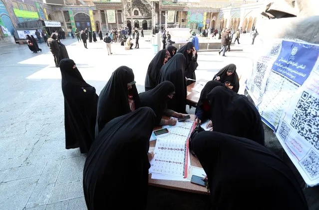 Veiled Iranian women fill their ballot papers during the Iranian legislative election at the Abdol-Azim shrine in Shahre-Ray, southern Tehran, Iran, 01 March 2024. Iranians vote for new members of Iran's parliament, and for the Assembly of Experts, the body in charge of appointing Iran's Supreme Leader. (Photo by Abedin Taherkenareh/EPA/EFE)