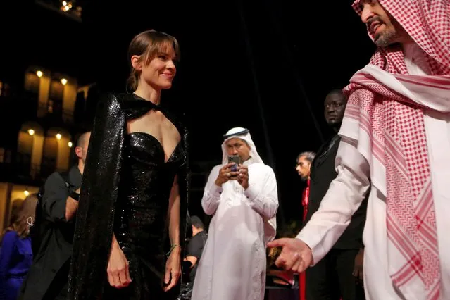 A handout picture released by the Red Sea Film Festival shows chairman Mohammed al Turki welcoming US actress Hillary Swank upon her arrival at the opening of the first edition of the festival in the Saudi city of Jeddah, on December 6, 2021. Less than four years after lifting a ban on cinemas, Saudi Arabia rolled out the red carpet in the Red Sea city of Jeddah for celebrities descending on the kingdom's first major film festival. (Photo by Patrick Baz/Red Sea Film Festival/AFP Photo)