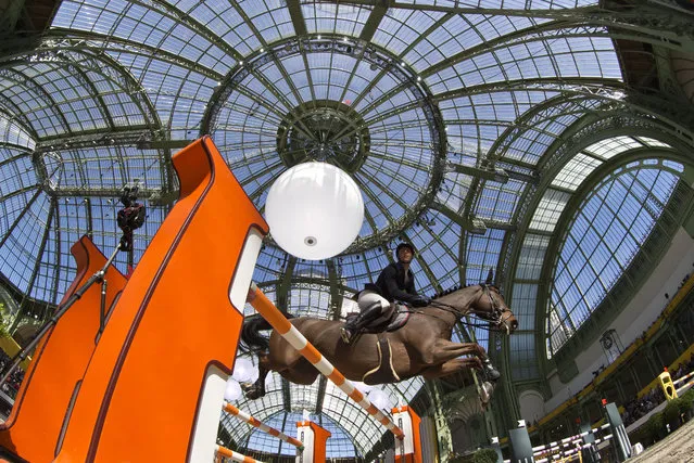 Alexandre Fontanelle of France, rides his horse Prime Time des Vagues during an equestrian team competition CSIU25 at the Grand Palais in Paris, Sunday, March 16, 2014. (Photo by Michel Euler/AP Photo)