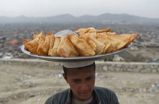 An Afghan samosa vendor looks on as he waits for customers at Wazir Akbar Khan hilltop overlooking Kabul on March 26 ,2019. (Photo by Wakil KohsarAFP Photo)