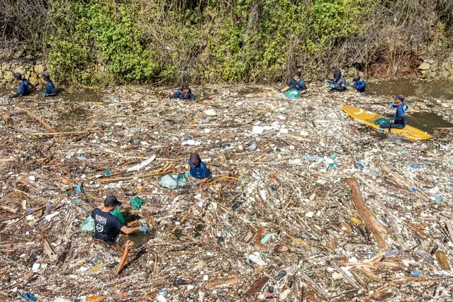 Environmental activists cleanup a river filled with plastic waste to mark World Water Day in Bali, Indonesia, 22 March 2024. A group of environmental activists cleaned up plastic waste that covered the entire surface of a river due to poor waste management. World Water Day is observed annually on 22 March that used to advocate for the sustainable management of freshwater resources. (Photo by Made Nagi/EPA/EFE)