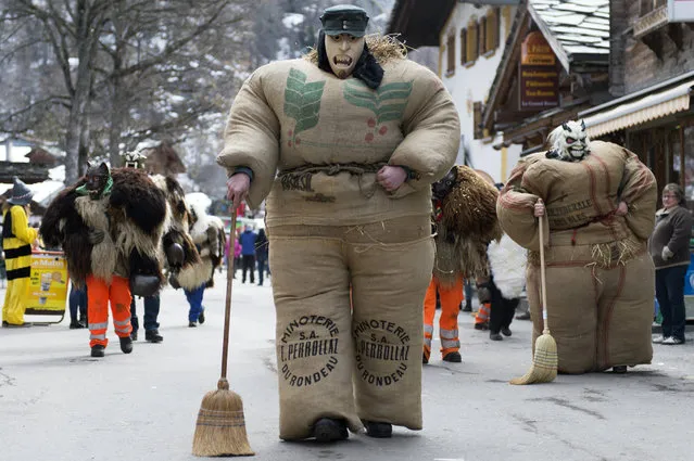 “Straw-men”, wearing masks and costumes made from jute bags stuffed with straw, take part in a carnival procession in Evolene, Switzerland, 26 February 2017. The straw men, known as empailles, are a traditional part of the annual carnival celebrations. (Photo by Thomas Delley/EPA)