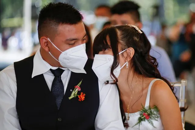 A newly-wed couple takes part in a collective wedding ceremony celebrated by the municipality, as the coronavirus disease (COVID-19) outbreak continues on Valentine's Day, in San Salvador, El Salvador February 14, 2021. (Photo by Jose Cabezas/Reuters)