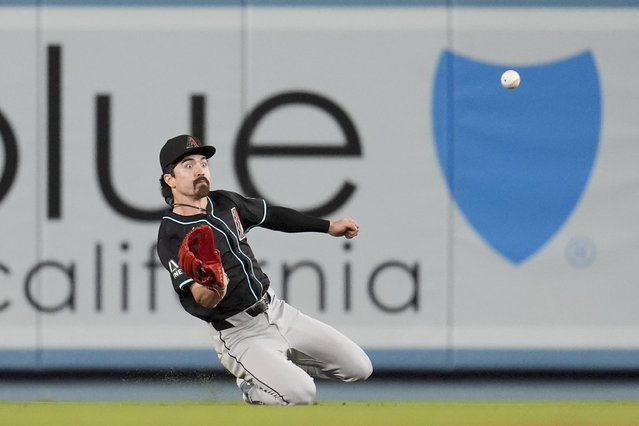 Arizona Diamondbacks center fielder Corbin Carroll makes a sliding catch on a line drive by Los Angeles Dodgers' Teoscar Hernández during the ninth inning of a baseball game Tuesday, May 21, 2024, in Los Angeles. (Photo by Marcio Jose Sanchez/AP Photo)