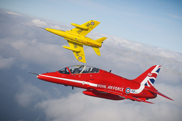 A vintage jet, of the type used by the original Red Arrows, flies alongside a present-day aircraft to help mark the team’s 60th display season in the first decade of March 2024. (Photo by UK Mod Crown  2024/The Times)