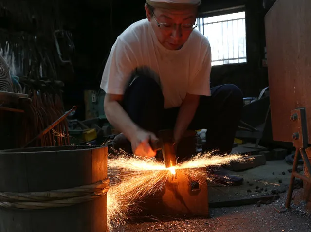Myouchin Keizo, 38, as he produces Hbashi iron bells made of iron at Myochin Honpo shop on April 25, 2014 in Himeji, Japan. Myochin family's iron business, started in the Heian period (794-1185) of Japan as an armor and helmet maker, shifted as the needs of people changed in the course of history. (Photo by Buddhika Weerasinghe/Getty Images)