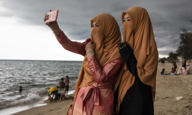 Veiled Thai women take a selfie on the Talo Kapo beach enjoying Eid al-Fitr on June 5, 2019 in Pattani, Thailand. Today is Eid al-Fitr, or Festival of Breaking the Fast, which marks the end of Ramadan, the Islamic holy month of fasting. (Photo by Paula Bronstein/Getty Images)