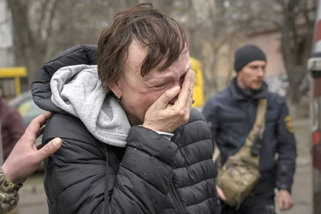 A woman evacuated from Irpin cries upon arriving on the outskirts of Kyiv, Ukraine, Saturday, March 26, 2022. Russia continues to pound cities throughout Ukraine – explosions rang out Saturday near the western city of Lviv, a destination for refugees that has been largely spared from major attacks. (Photo by Vadim Ghirda/AP Photo)