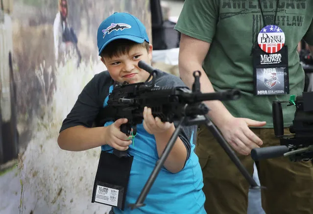 Christian Florea, 10,  looks over an FN MK 48 machine gun at the NRA Annual Meetings & Exhibits on May 21, 2016 in Louisville, Kentucky. (Photo by Scott Olson/Getty Images)