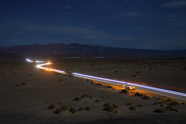 This long exposure image shows the path of runners and their support vehicles under a moon light sky on California Route 190 during the Badwater 135 mile (217 kilometer) ultramarathon in Death Valley, Calif., Tuesday, July 23, 2024. (Photo by Ty ONeil/AP Photo)