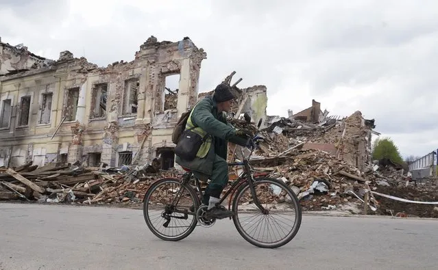 A local Ukrainian man ride bicycle in front of a destroyed shelling building in Kharkiv, Ukraine, 24 April 2022, amid Russian invasion. (Photo by Vasiliy Zhlobsky/EPA/EFE)