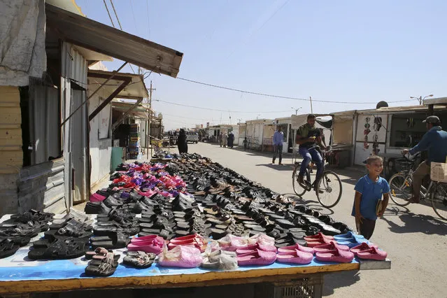 In this Wednesday, July 29, 2015 photo, Syrian refugees ride bicycles at a market at Zaatari refugee camp, in Mafraq, Jordan. On Zaatari's anniversary this past week, the transformation from tent camp to city symbolizes the failure of rival world powers to negotiate an end Syria's war. But some say it's also a reminder that the shift from emergency aid to long-term solutions, such as setting up a water network to replace expensive delivery by truck, should have come much sooner. (Photo by Raad Adayleh/AP Photo)