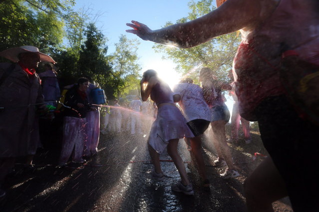 Revelers spray wine on people as they take part in the “Battle of Wine” (La batalla del vino de Haro), a wine fight, during the Haro Wine Festival, in Haro, in the northern province of La Rioja on June 29, 2014. More than nine thousand locals and tourists threw around 130.000 litres of wine at each other during the Haro Wine Festival, according to local media. (Photo by Cesar Manso/AFP Photo)