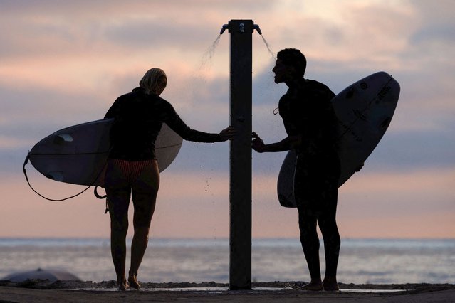 Surfers wash off at an outdoor beach shower as Southern California faces an excessive heat warning for the remainder of the week in Oceanside, California, U.S., September 3, 2024. (Photo by Mike Blake/Reuters)