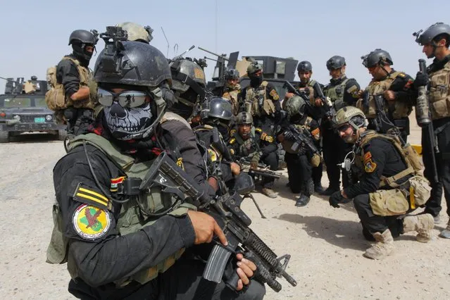 Members of the Iraqi Special Operations Forces (ISOF) prepare before going out on a patrol in the town of Jurf al-Sakhar, south of Baghdad, June 30, 2014. Iraqi troops battled to dislodge an al Qaeda splinter group from the city of Tikrit on Monday after its leader was declared caliph of a new Islamic state in lands seized this month across a swathe of Iraq and Syria. (Photo by Alaa Al-Marjani/Reuters)