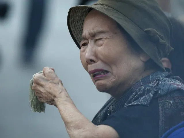 A woman reacts as she prays for the atomic bomb victims in front of the cenotaph for the victims of the 1945 atomic bombing, at Peace Memorial Park in Hiroshima, western Japan, August 6, 2015, on the 70th anniversary of the world's first atomic bombing of the city. (Photo by Toru Hanai/Reuters)