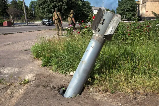 An unexploded shell of a multiple rocket launch system is seen stuck in the ground, as Russia's attack on Ukraine continues, in the town of Lysychansk, Luhansk region, Ukraine on June 10, 2022. (Photo by Oleksandr Ratushniak/Reuters)