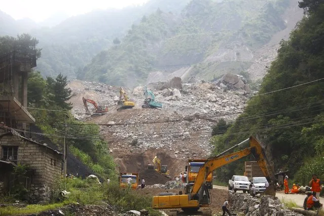 Rescue workers search at the site of a mining factory after a landslide hit Shanyang county, Shaanxi province, August 12, 2015. According to Xinhua News Agency, rescuers have dug out four people from their dormitories and houses buried in the landslide on Wednesday. Around 40 people are still missing. (Photo by Reuters/Stringer)