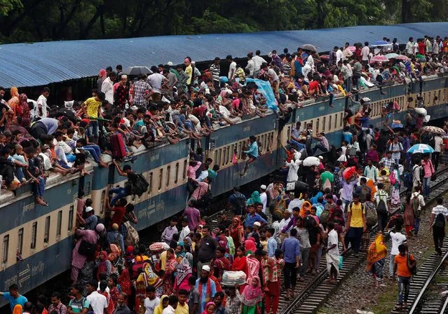 People climb to board an overcrowded passenger train as they travel home to celebrate Eid al-Fitr festival, which marks the end of the Muslim holy fasting month of Ramadan, at a railway station in Dhaka, Bangladesh, July 5, 2016. (Photo by Adnan Abidi/Reuters)