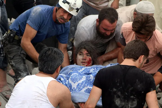 Men carry an injured girl after an airstrike on Aleppo's rebel held Kadi Askar area, Syria July 8, 2016. (Photo by Abdalrhman Ismail/Reuters)