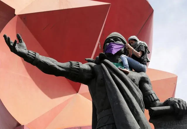 A woman ties a handkerchief over the mouth of the statue of pre-Columbian ruler Nezahualcoyotl, during International Women's Day in Ciudad Nezahualcoyotl, on the outskirts of Mexico City, Mexico on March 8, 2020. (Photo by Raquel Cunha/Reuters)