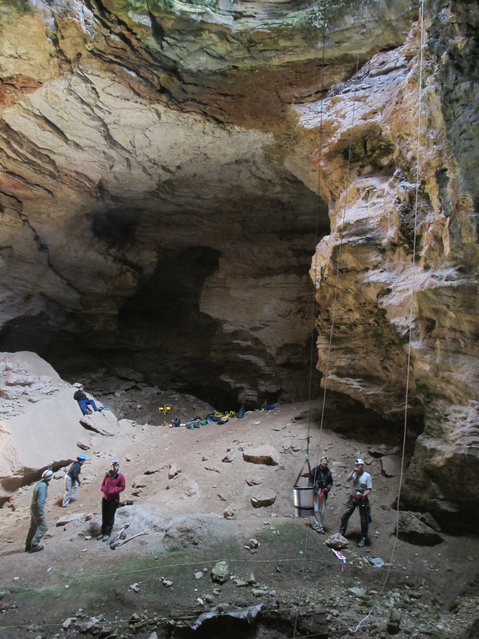 This July 2014 image provided by the Bureau of Land Management shows researchers in the interior of the Natural Trap Cave in north-central Wyoming. The cave holds the remains of tens of thousands of animals, including many now-extinct species, from the late Pleistocene period tens of thousands of years ago. Scientists have resumed digging for the first time in more than 30 years. (Photo by AP Photo/Bureau of Land Management)