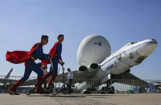 Promoters skate past a Myasishchev VM-T Atlant strategic airlift airplane on display at the MAKS International Aviation and Space Salon in Zhukovsky, outside Moscow, Russia, August 25, 2015. (Photo by Maxim Shemetov/Reuters)