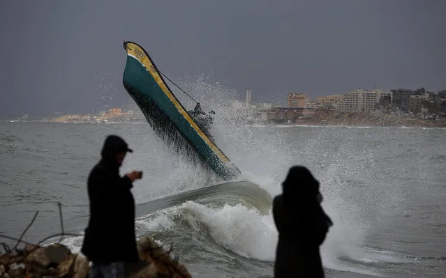 Palestinian fishermen ride their boat amid high waves on windy and rainy day at the sea in Gaza City, Sunday, February 9, 2020. (Photo by Hatem Moussa/AP Photo)