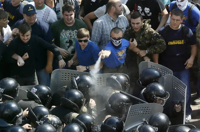 Demonstrators, who are against a constitutional amendment on decentralization, clash with police outside the parliament building in Kiev, Ukraine, August 31, 2015. But many coalition allies, including former prime minister Yulia Tymoshenko, spoke against it and it is open to question whether Poroshenko will be able to whip up the necessary 300 votes for it to get through a second and final reading later this year. (Photo by Valentyn Ogirenko/Reuters)