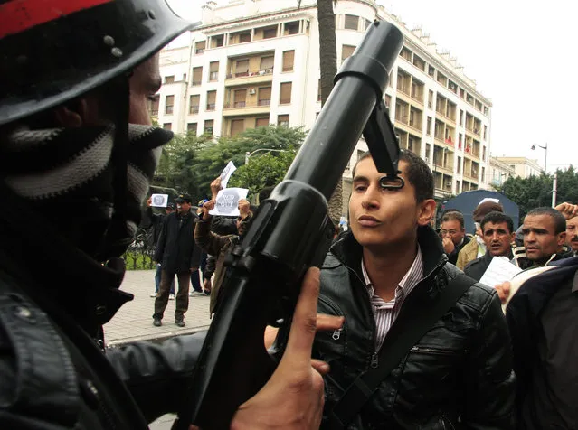 A riot policeman faces off with a protester during a demonstration in downtown Tunis January 18, 2011. (Photo by Zoubeir Souissi/Reuters)