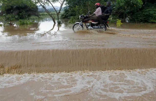 A motorcyclist with a pillion rides through flood waters on a street in Abuja, Nigeria, September 3, 2015. (Photo by Afolabi Sotunde/Reuters)