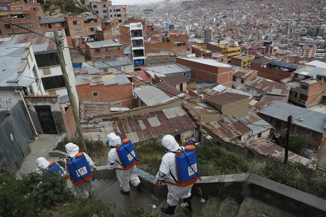 City workers disinfect a stairway in attempt to help contain the spread of the new coronavirus, in La Paz, Bolivia, Tuesday, April 28, 2020. (Photo by Juan Karita/AP Photo)