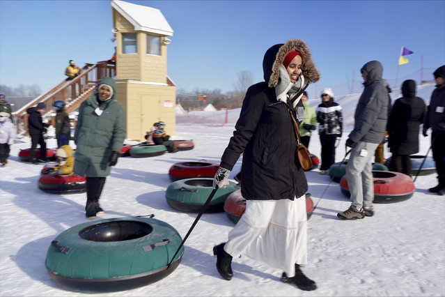 Nasrieen Habib, left, and Makiya Amin pull their snow tubes on top of a hill during an outing organized by the group Habib founded to promote outdoors activities among Muslim women, at Elm Creek Park Reserve in Maple Grove, Minn., January 4, 2025. (Photo by Mark Vancleave/AP Photo)