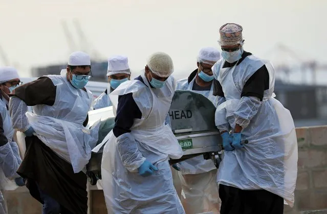 Family members and funeral workers carry the coffin of a 51-year-old man who died from the coronavirus disease (COVID-19), at a cemetery in Cape Town, South Africa, May 12, 2020. (Photo by Sumaya Hisham/Reuters)