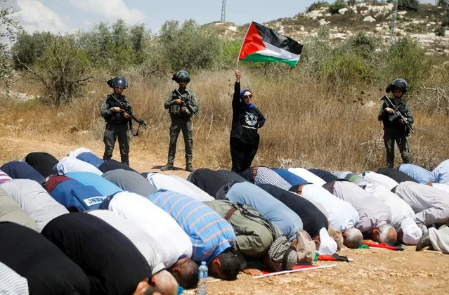 Palestinians pray during a protest against Israeli settlement activity in Bayt Lid town, in Tulkarm in the Israeli-occupied West Bank on August 26, 2022. (Photo by Raneen Sawafta/Reuters)