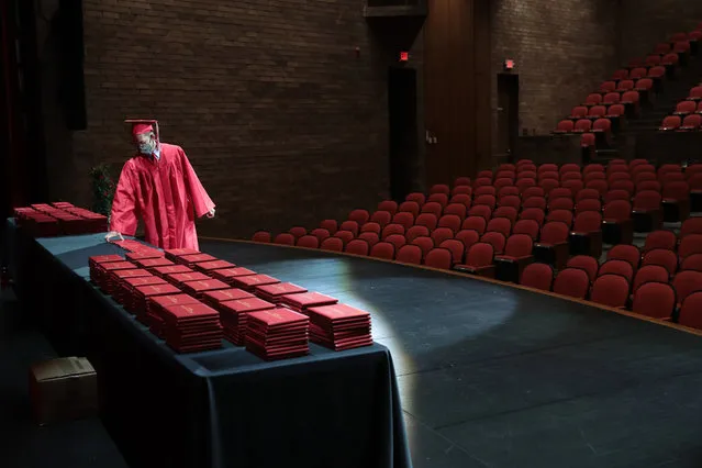 A student picks up his diploma during a graduation ceremony at Bradley-Bourbonnais Community High School on May 06, 2020 in Bradley, Illinois. Because of social distancing mandates instituted by the state to curtail the spread of COVID-19, graduates received their diplomas in a nearly-empty auditorium with no friends, family or relatives allowed to attend. A video of the event will be streamed for others to view on the the school's scheduled graduation date of May 16.  The school, located about 60 miles south of Chicago, has about 2,100 students, 523 were graduating. (Photo by Scott Olson/Getty Images)