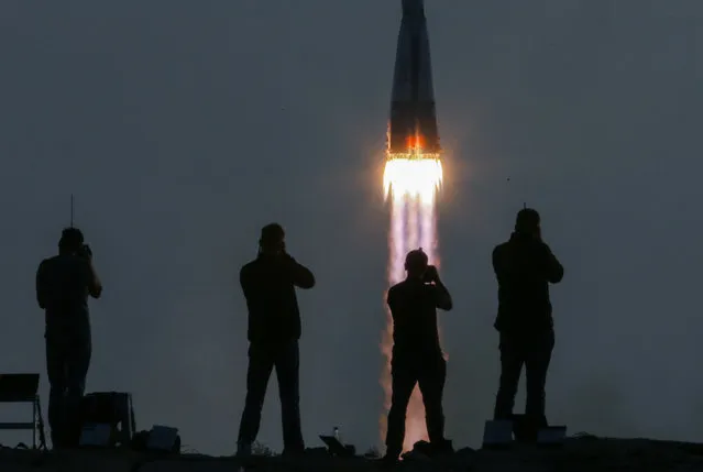 Photographers take pictures as the Russian Soyuz MS-01 spacecraft with crewmembers of the 48/49 expedition to the International Space Station (ISS), NASA astronaut Kate Rubins, cosmonaut Anatoly Ivanishin of the Russian space agency Roscosmos, and astronaut Takuya Onishi of the Japan Aerospace Exploration Agency (JAXA) aboard, lifts off from the Cosmodrome Baikonur in Kazakhstan, 07 July 2016. Rubins, Ivanishin, and Onishi will spend approximately four months on the orbital complex, returning to Earth in October. (Photo by Sergei Ilnitsky/EPA)