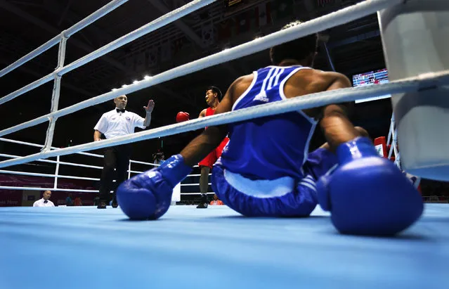 Bhutan's Sigyel Phub (C) reacts after Pakistan's Nadir fell during their Men's Bantam Weight preliminary boxing bout at Seonhak Gymnasium during the 17th Asian Games in Incheon September 24, 2014. (Photo by Tim Wimborne/Reuters)