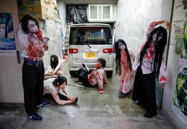 Actors dressed as zombies or ghouls stretch before their performance at a drive-in haunted house show, performed by Kowagarasetai (Scare Squad), for people inside a car in order to maintain social distancing amid the spread of the coronavirus disease (COVID-19), at a garage in Tokyo, Japan on July 3, 2020. (Photo by Issei Kato/Reuters)