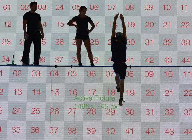 Artists perform in front of a screen at the booth of Busch-Jaeger at the IFA (Internationale Funkausstellung) electronics trade fair in Berlin on September 1, 2016. 
The IFA is considered the worldwide biggest leading fair for entertainment electronics, IT and household appliances and opens its doors from September 2 till 7. (Photo by Tobias Schwarz/AFP Photo)