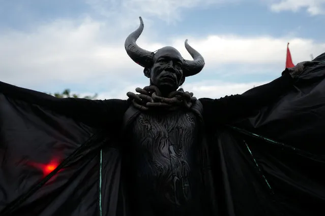 A man dressed as the “Bat King” walks down the street as he takes part in the overnight-into-dawn celebration called J'Ouvert, ahead of the annual West Indian-American Carnival Day Parade in Brooklyn, NY, U.S. September 5, 2016. The Labor Day Carnival (or West Indian Carnival) is an annual celebration held on American Labor Day (the first Monday in September) in Crown Heights, Brooklyn, in New York City. The main event is the West Indian Day Parade, which attracts between one and three million participants. Jessie Waddell and some of her West Indian friends started the Carnival in Harlem in the 1920s by staging costume parties in large enclosed places like the Savoy, Renaissance and Audubon Ballrooms due to the cold wintry weather of February. (Photo by Mark Kauzlarich/Reuters)