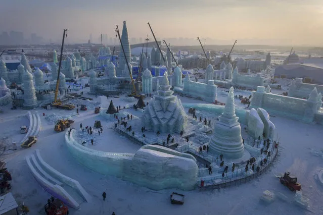 An aerial view taken with a drone shows the construction site for the Harbin Ice and Snow World in Harbin in northeastern China's Heilongjiang province Saturday, December 16, 2017. The annual Harbin Ice Festival is a popular winter tourist site as blocks of ice are assembled into fantasy buildings lit with colored lights. (Photo by Chinatopix via AP Photo)