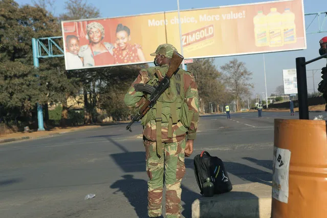 An armed soldier stands on a deserted street in Harare, Friday, July, 31, 2020. Zimbabwe's capital, Harare, was deserted Friday, as security agents vigorously enforced the country's lockdown amidst planned protests. Police and soldiers manned checkpoints and ordered people seeking to get into the city for work and other chores to return home. (Photo by Tsvangirayi Mukwazhi/AP Photo)