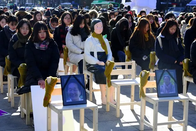 People sit around a statue of a “comfort woman” (C) during an installation of empty chairs during a performance event, commemorating the death of eight former s*x slaves this year, in Seoul on December 27, 2017. South Korea said on December 27 a 2015 deal intended to end a festering dispute with Japan over Tokyo's wartime s*x slavery was faulty, reopening a historical wound as the two countries try to rein in North Korea. (Photo by Jung Yeon-Je/AFP Photo)