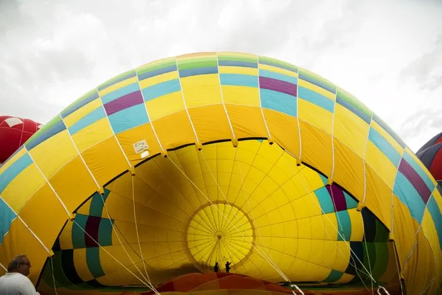 Two men walk inside a hot air balloon as it is prepared for lift off on the first day of the 2015 Albuquerque International Balloon Fiesta in Albuquerque, New Mexico, October 3, 2015. (Photo by Lucas Jackson/Reuters)