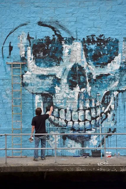 A man paints a skull at an artificial beach in Brussels, Belgium, July 4, 2015. (Photo by Eric Vidal/Reuters)