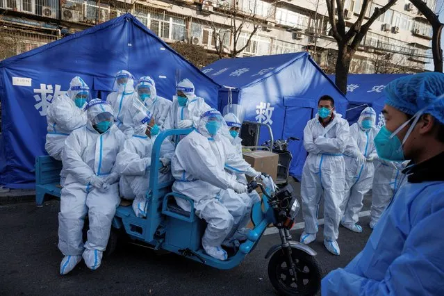 Pandemic prevention workers gather before their shift to look after buildings where residents do home quarantine, as coronavirus disease (COVID-19) outbreaks continue in Beijing on December 8, 2022. (Photo by Thomas Peter/Reuters)