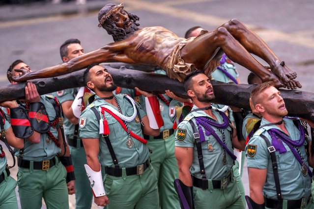 Members of the Spanish Legion, an elite unit of the Spanish Army, hold up the El Cristo de la Buena Muerte, or Christ of the Good Death, during a ceremony ahead of the procession in Malaga, Southern Spain, southern Spain, Thursday, March 28, 2024. Hundreds of processions will take place throughout Spain during the Easter Holy Week. (Photo by Manu Fernandez/AP Photo)
