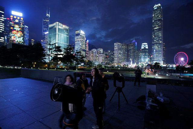 People set up telescopes in front of the financial Central district for the super blue moon and eclipse in Hong Kong on January 31, 2018. (Photo by Bobby Yip/Reuters)