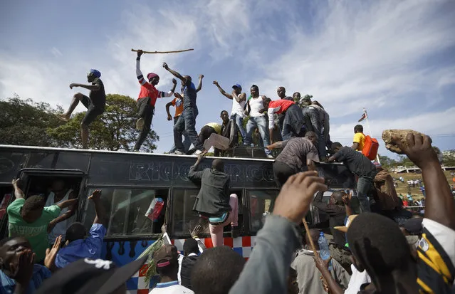 Supporters of opposition leader Raila Odinga arrive by bus, as they gather in advance of a mock “swearing-in” ceremony of Odinga at Uhuru Park in downtown Nairobi, Kenya Tuesday, January 30, 2018. Odinga is due Tuesday to hold a so-called “inauguration” of himself in protest of President Uhuru Kenyatta's new term following the divisive 2017 election. (Photo by Ben Curtis/AP Photo)